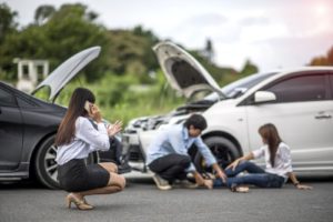 Injured women gets treatment from a person on a car accident spot